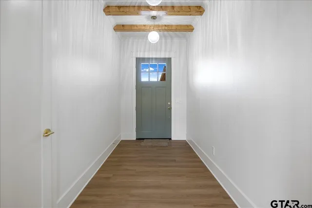 a view of a hallway with wooden floor