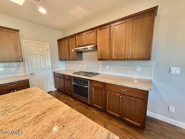 a kitchen with stainless steel appliances granite countertop a stove a sink and a refrigerator