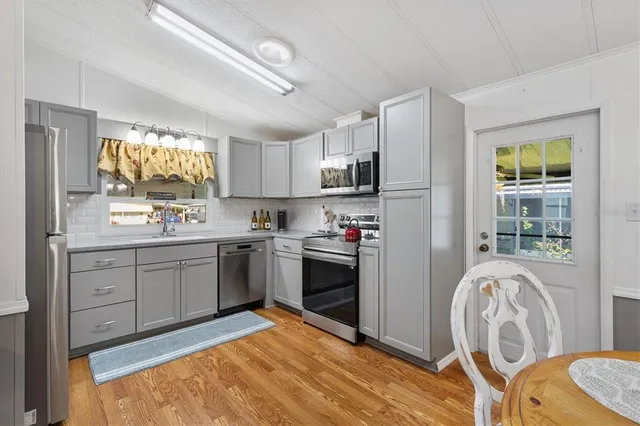 a kitchen with granite countertop a stove top oven sink and cabinets