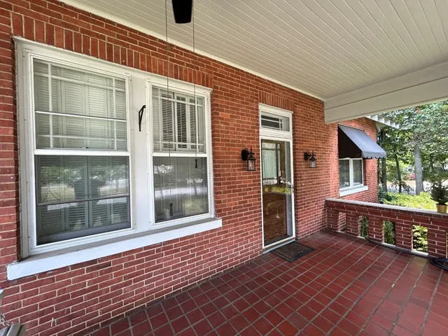 a view of front door of house with wooden deck