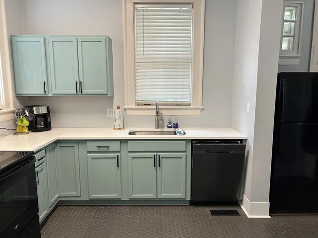 a kitchen with a sink cabinets and a refrigerator