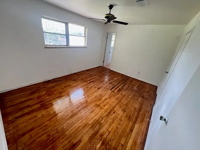 a view of empty room with wooden floor