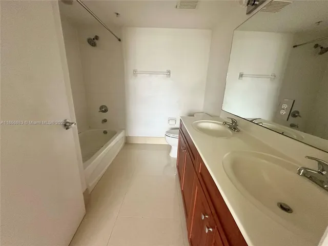 a bathroom with a tub sink and mirror