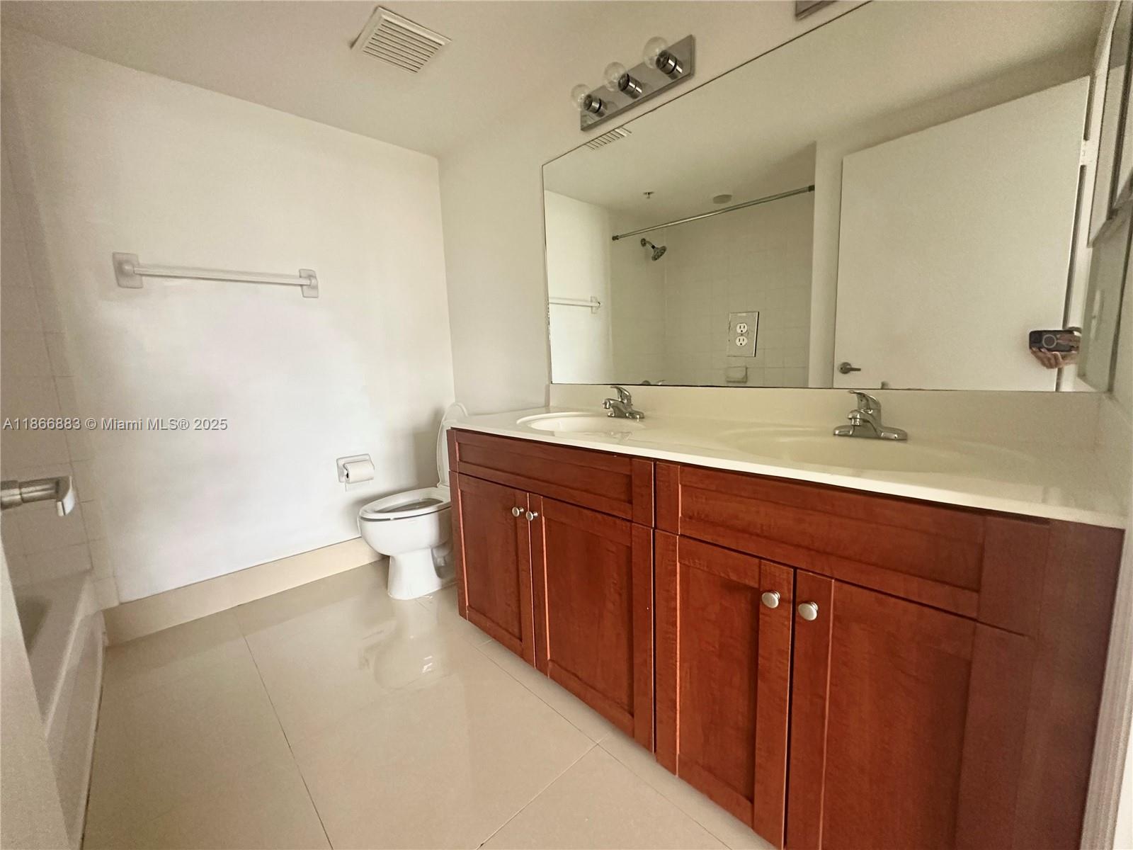36 Northwest 6th Avenue, Unit 806 Miami, FL 33128 - Photo 16 of 23 a spacious bathroom with a granite countertop sink a toilet and a mirror