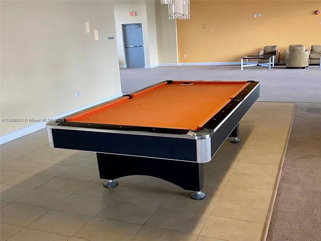 a room with pool table and glass windows