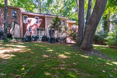 a view of a brick house with a yard and plants
