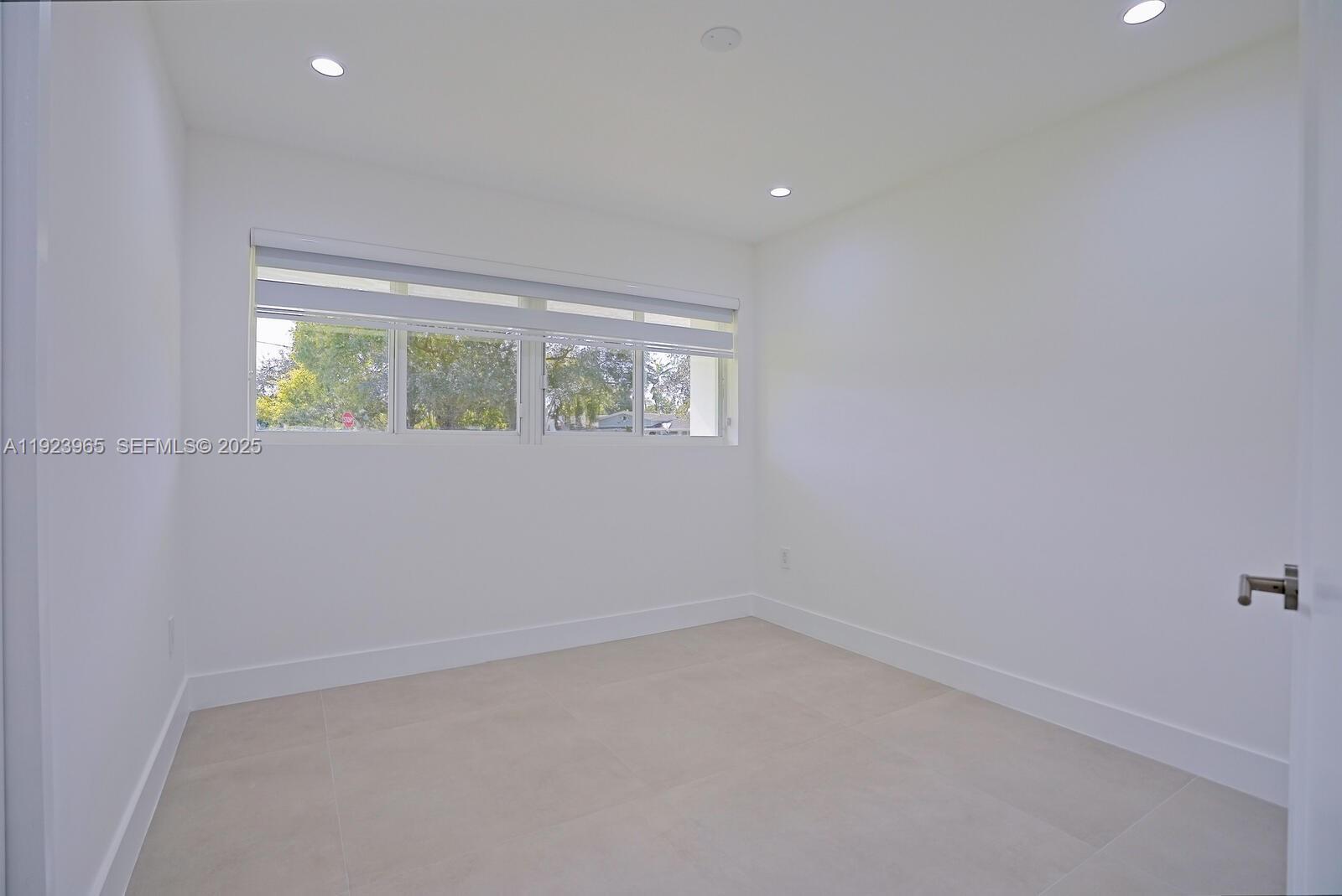 9301 Southwest 178th Street Palmetto Bay, FL 33157 - Photo 18 of 23 wooden floor in an empty room with a window