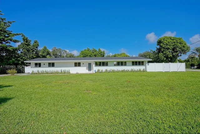 a view of house with garden space and sitting area