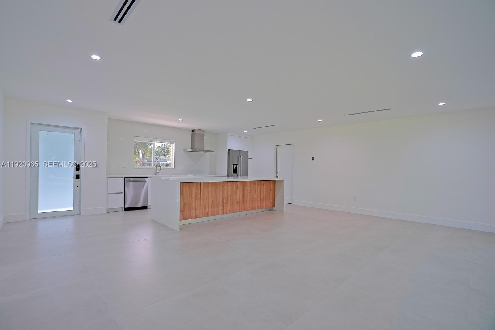 9301 Southwest 178th Street Palmetto Bay, FL 33157 - Photo 4 of 23 a view of an empty room with wooden floor and windows