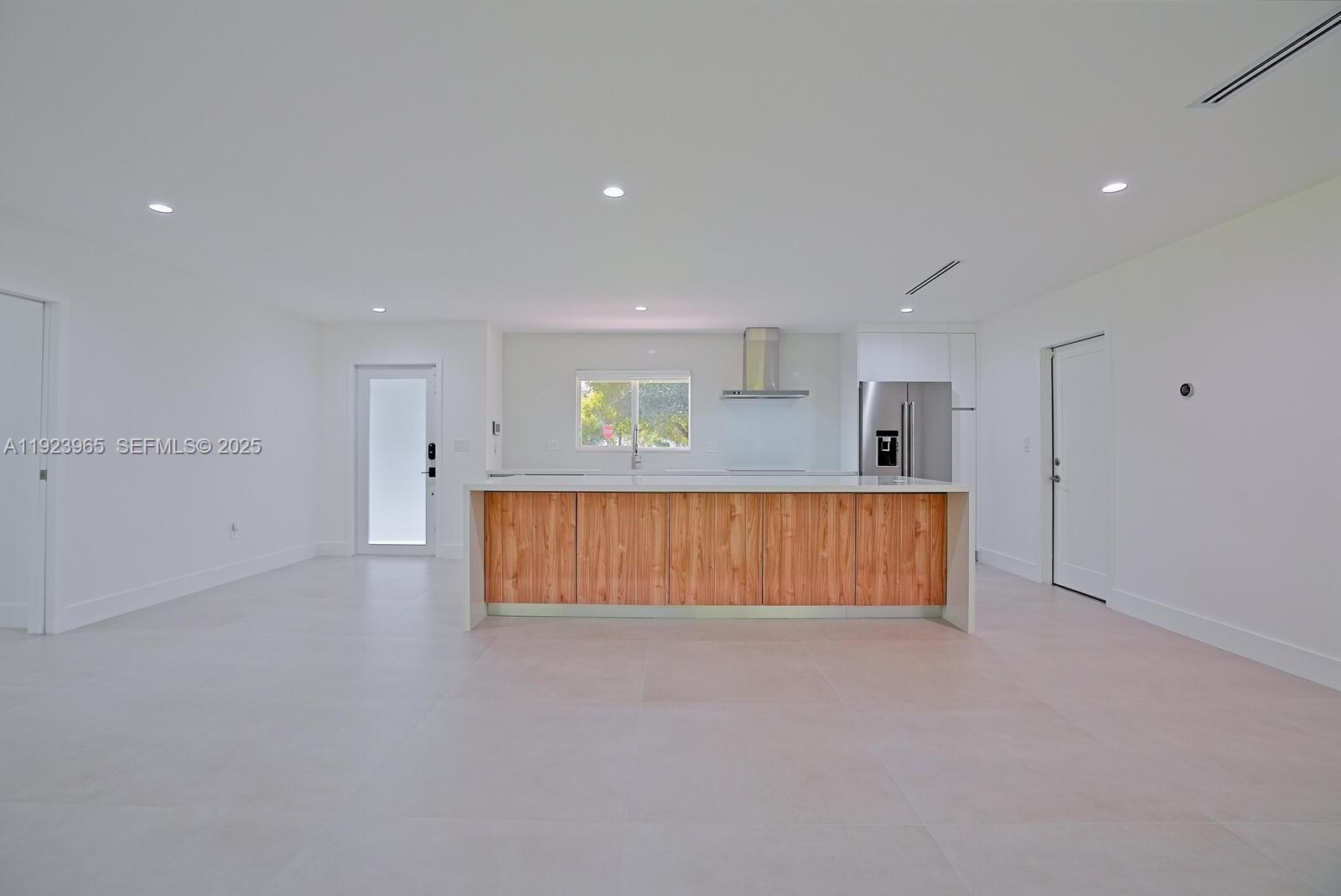 9301 Southwest 178th Street Palmetto Bay, FL 33157 - Photo 5 of 23 an empty room with wooden floor and windows