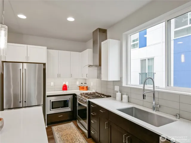 a kitchen with granite countertop a sink stove and refrigerator