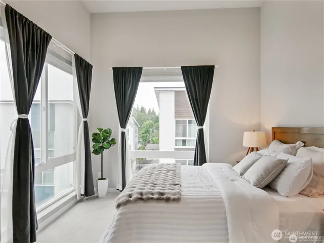 a bedroom with furniture and a large window