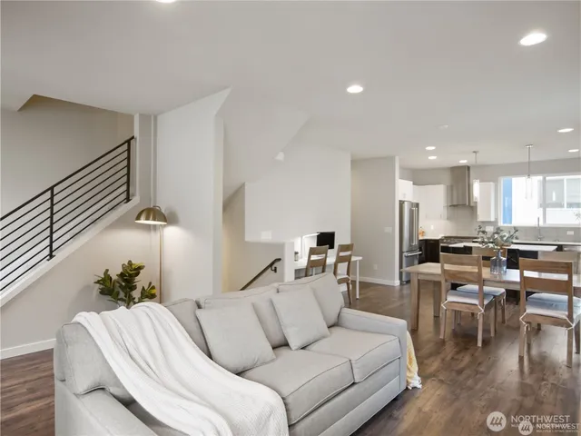 a living room with furniture and a dining table with wooden floor