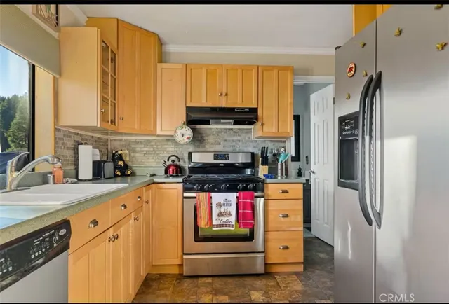 a kitchen with stainless steel appliances granite countertop a stove a refrigerator and a sink