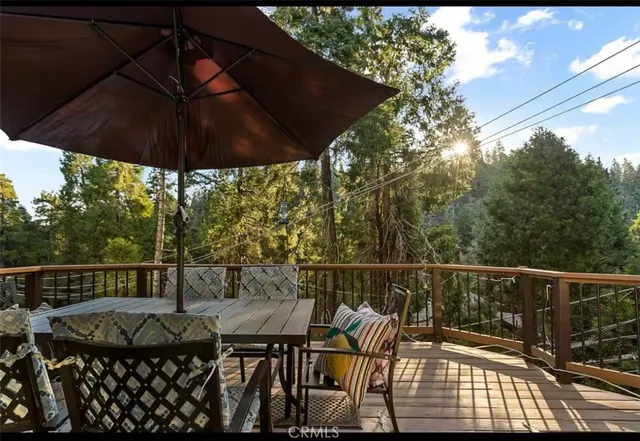 a view of a roof deck with table and chairs under an umbrella