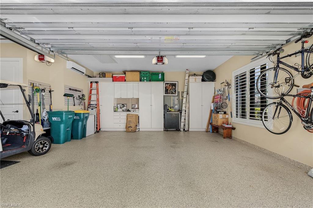 2220 Residence Circle Naples, FL 34105 - Photo 39 of 50 Garage with a wall mounted air conditioner and a garage door opener