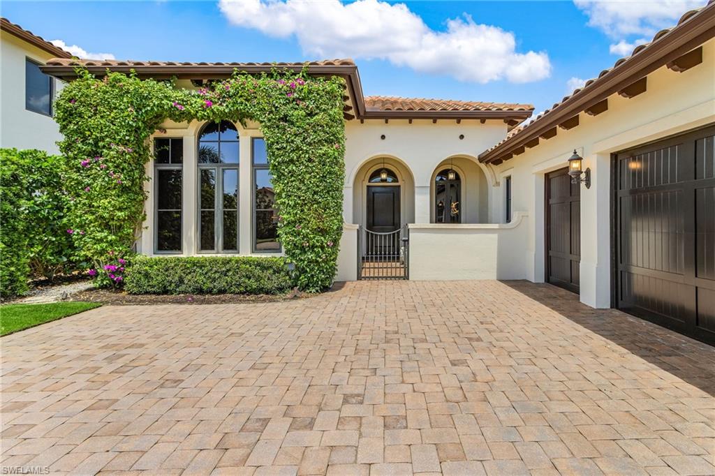 2220 Residence Circle Naples, FL 34105 - Photo 5 of 50 View of patio / terrace with a gate, decorative driveway, and an attached garage
