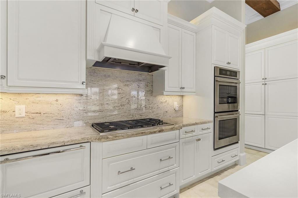 2220 Residence Circle Naples, FL 34105 - Photo 10 of 50 Kitchen featuring white cabinets, stainless steel appliances, premium range hood, and backsplash