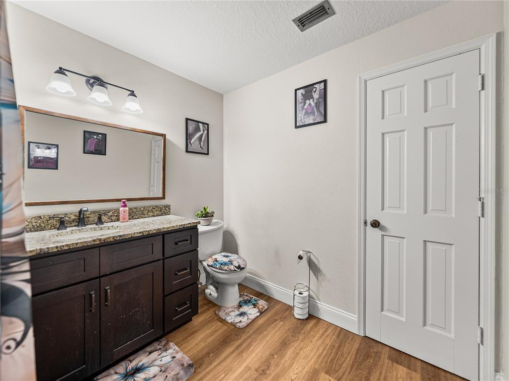 609 West Pipkin Road Lakeland, FL 33813 - Photo 39 of 72 a bathroom with a granite countertop sink mirror vanity and toilet