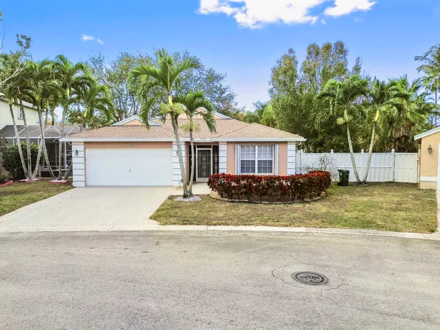 a view of a house with a yard and palm trees