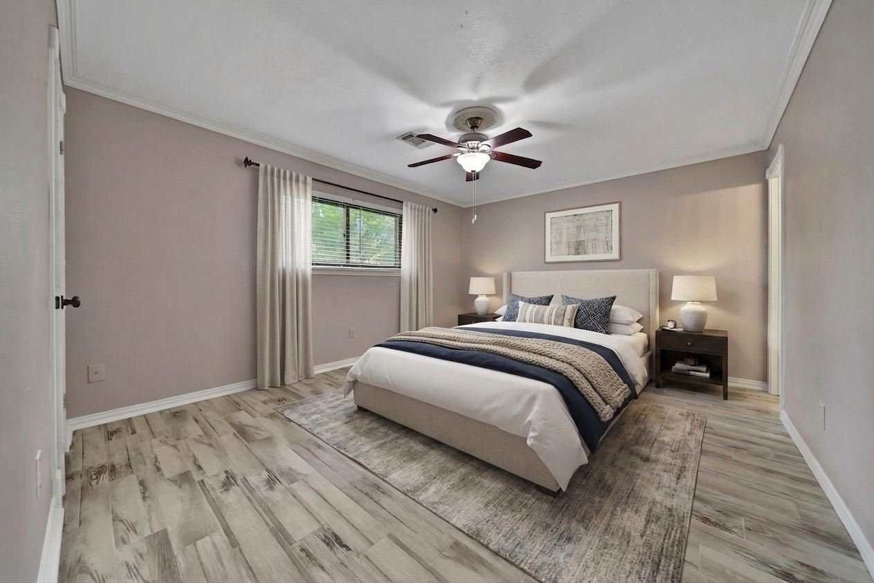 2006 Mermaid Lane Houston, TX 77062 - Photo 18 of 35 a bedroom with a large bed and a chandelier