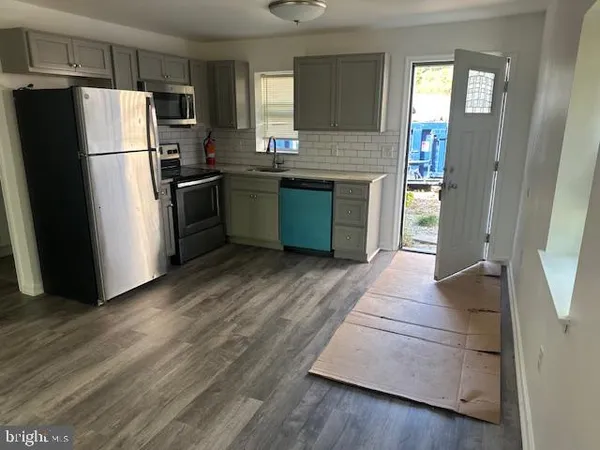 a kitchen with granite countertop a refrigerator and a sink