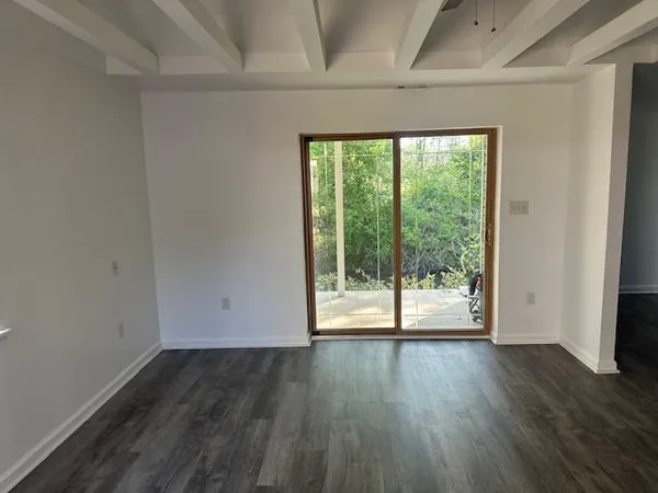 a view of a room with wooden floor and window
