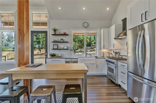 a kitchen with kitchen island a large counter appliances a sink and cabinets