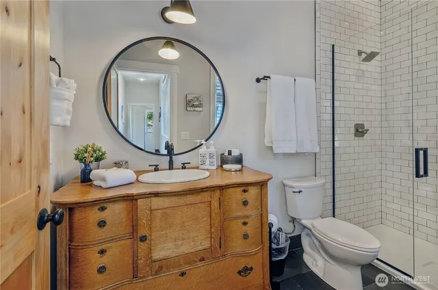 a bathroom with a granite countertop toilet sink and mirror