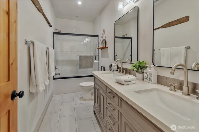 a bathroom with a granite countertop sink mirror and a shower