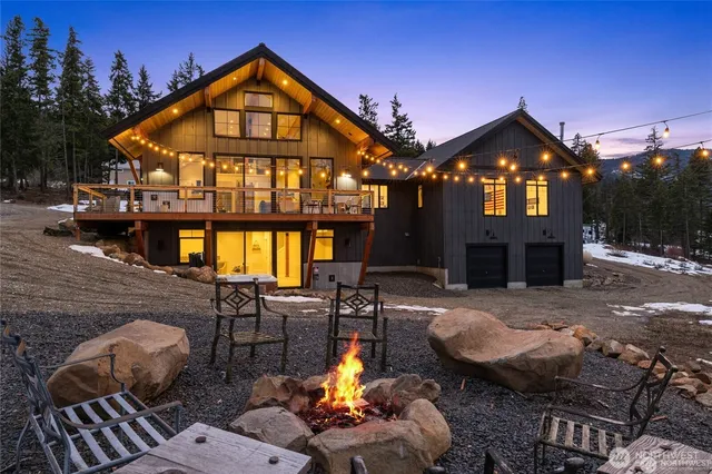 a view of a brick house with couches chairs and a fire pit