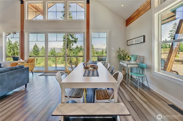 a view of a dining room with furniture large windows and wooden floor