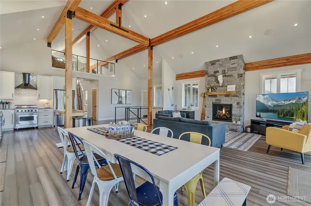 a living room with furniture a fireplace and a dining table with wooden floor