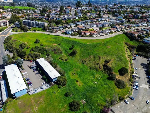 an aerial view of residential houses with outdoor space and trees