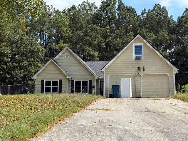 a front view of house with yard and trees around