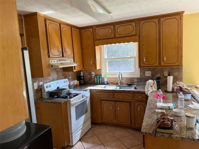 a kitchen with a sink stove and cabinets