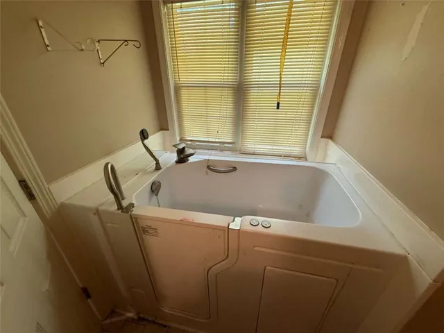 a bathroom with a bathtub and window