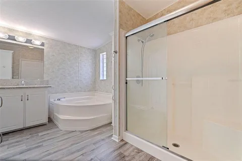 a spacious bathroom with a shower a sink and a mirror