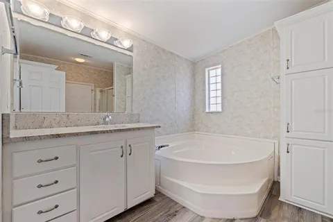 a bathroom with a tub sink and mirror
