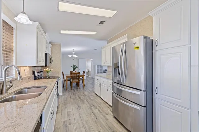 a kitchen with a refrigerator a sink and a stove top oven