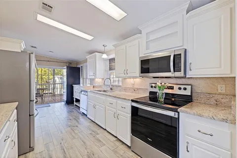 a kitchen with stainless steel appliances a stove sink microwave and cabinets