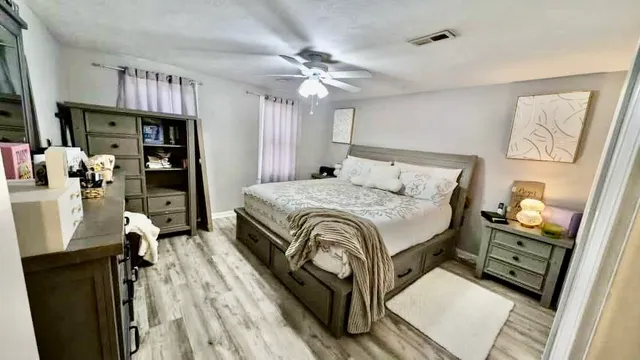 a spacious bedroom with a bed and a chandelier