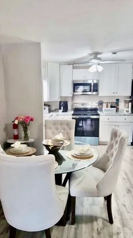 a kitchen with stainless steel appliances kitchen island granite countertop a kitchen island and chairs in it