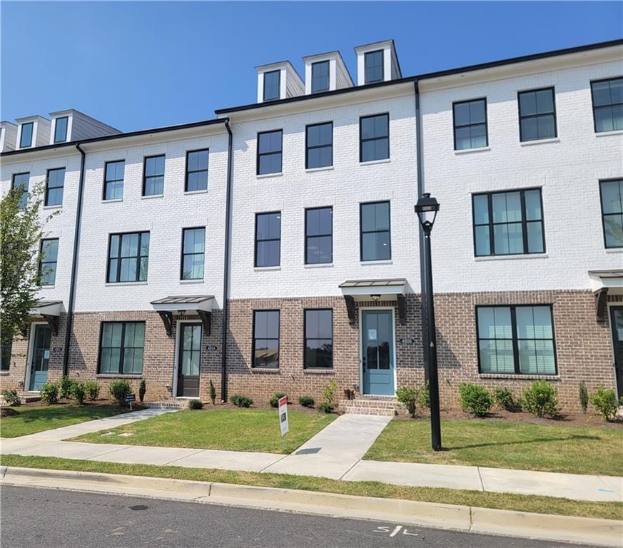 4806 Larkin Pass Buford, GA 30518 - Photo 1 of 23 a front view of a residential apartment building with a yard