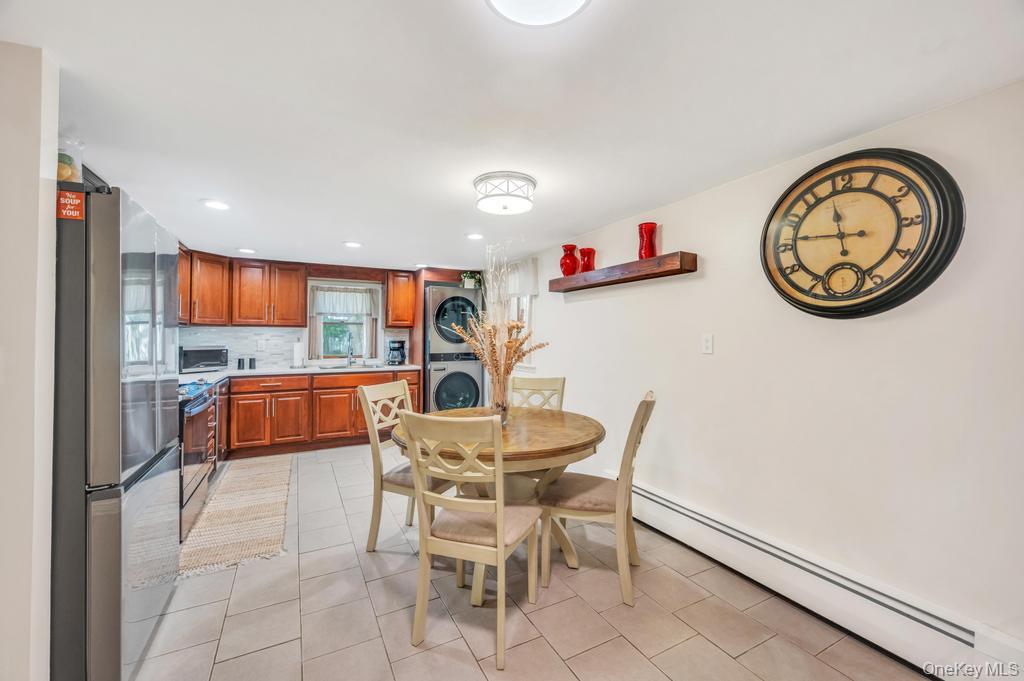 5 Panther Path Miller Place, NY 11764 - Photo 23 of 37 Dining room featuring a baseboard heating unit, light tile patterned floors, stacked washer and clothes dryer, and recessed lighting