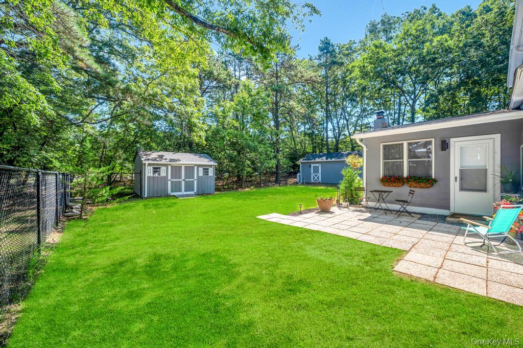 5 Panther Path Miller Place, NY 11764 - Photo 10 of 37 Fenced backyard featuring a storage shed, a patio, and view of scattered trees