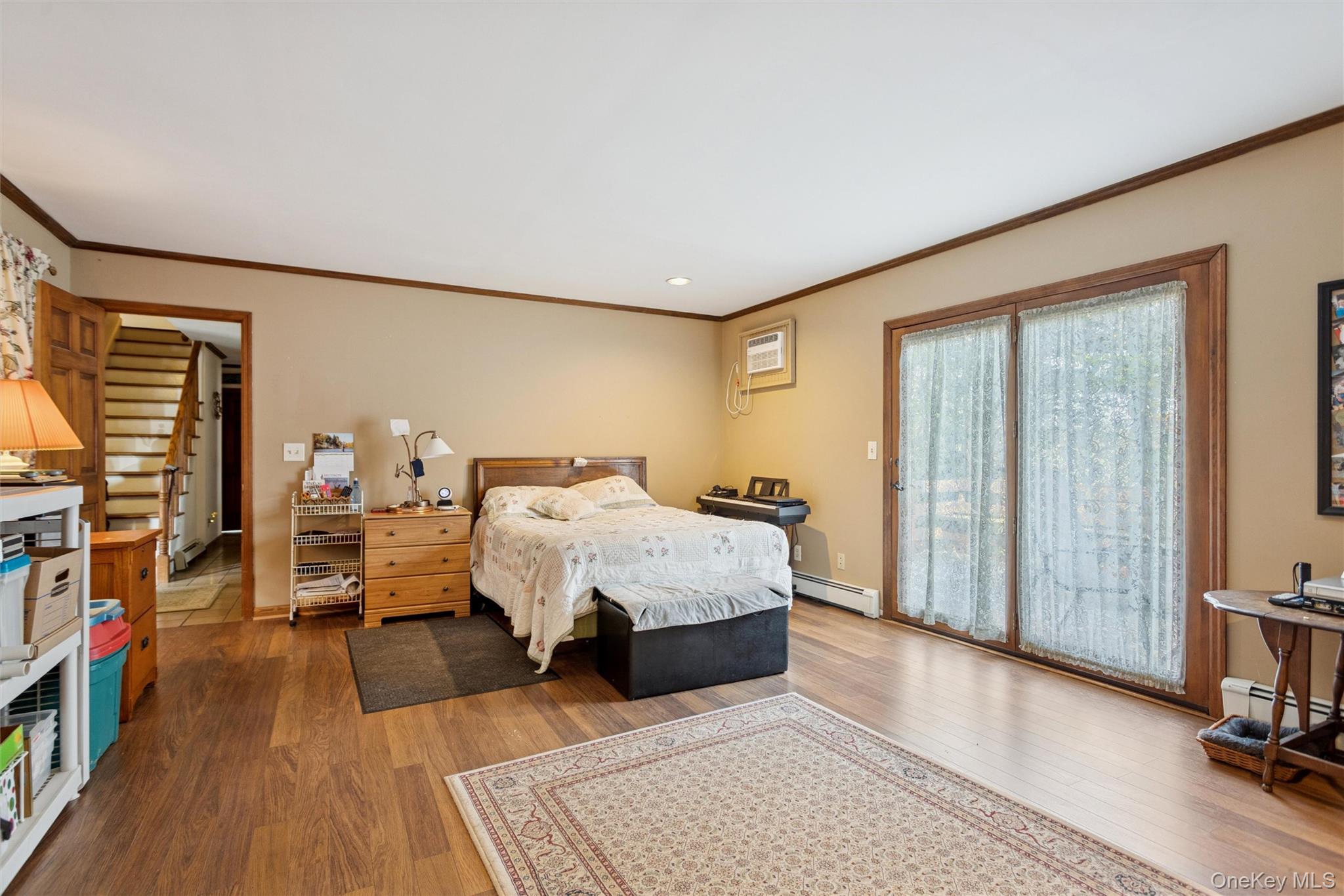 686 Traver Road Pleasant Valley, NY 12569 - Photo 17 of 37 a spacious bedroom with a bed a couch and a bookshelf with wooden floor
