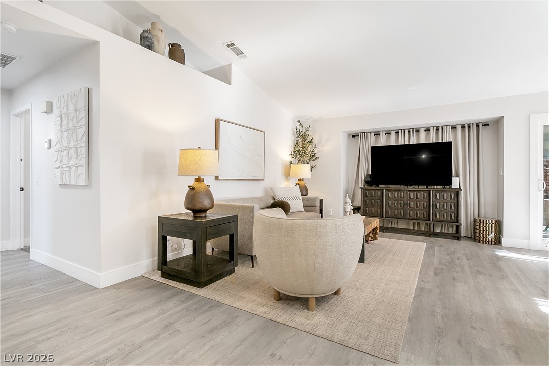 101 Beaver Ridge Avenue North Las Vegas, NV 89031 - Photo 2 of 42 An inviting gathering space features vaulted ceilings and light wood-look flooring.