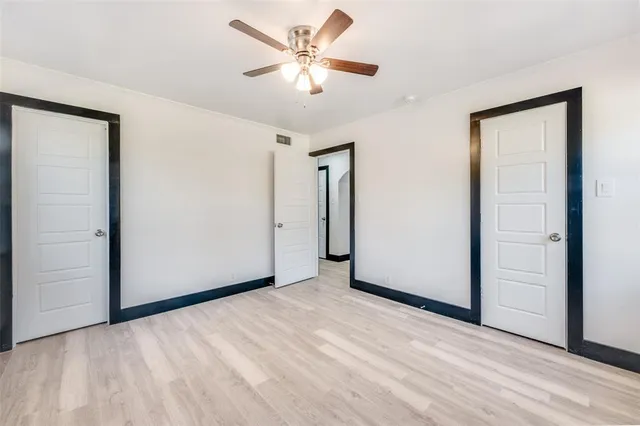 an empty room with closet and a ceiling fan