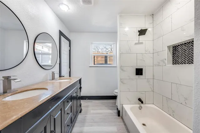 a bathroom with a tub sink and mirror